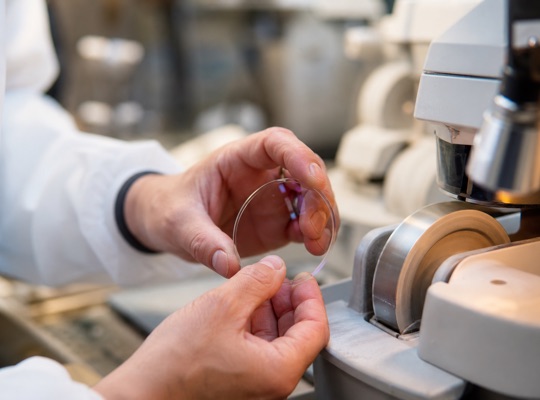 Optician shaping a lens at the in-house optical lab