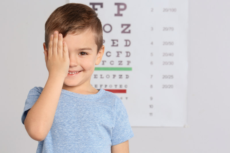 Child reading a vision chart during an eye exam